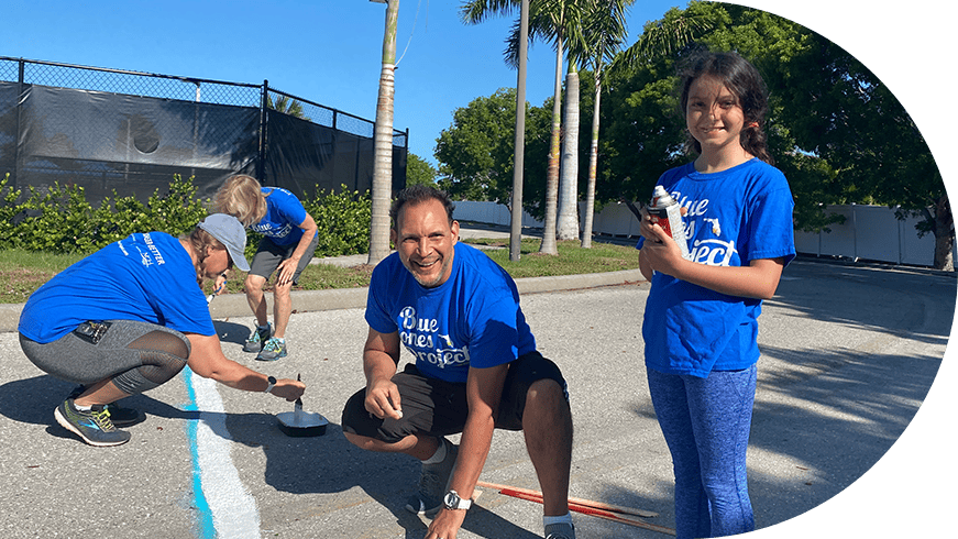 Three Blue Zones Project volunteers painting the pavement